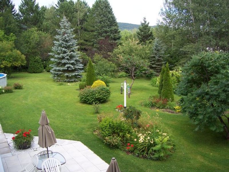 Cours extérieur avec jardin et terrasses de notre auberge «Les Studios du Vacancier» à St-Donat dans Lanaudière
