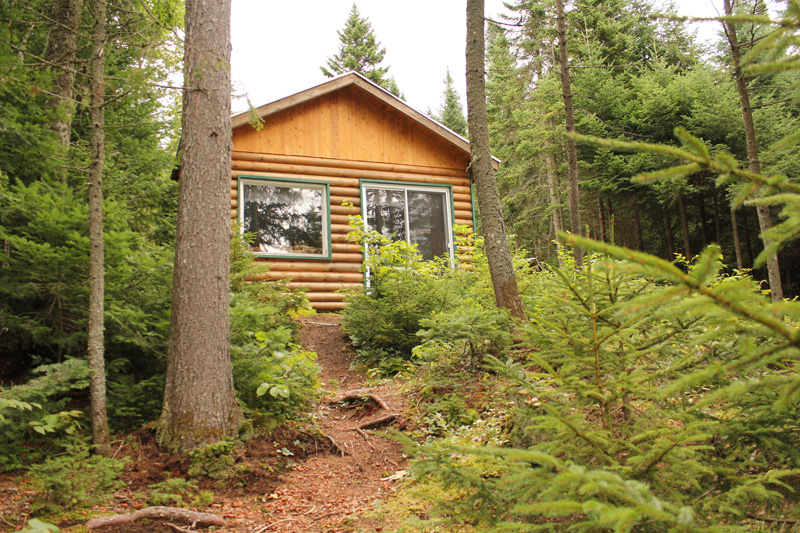 Vue de la façade du refuge le Philosore, refuge en bois rond, entouré par la nature, l'un des hébergements offerts dans la gamme des Refuges, en pleine nature à la Vallée.